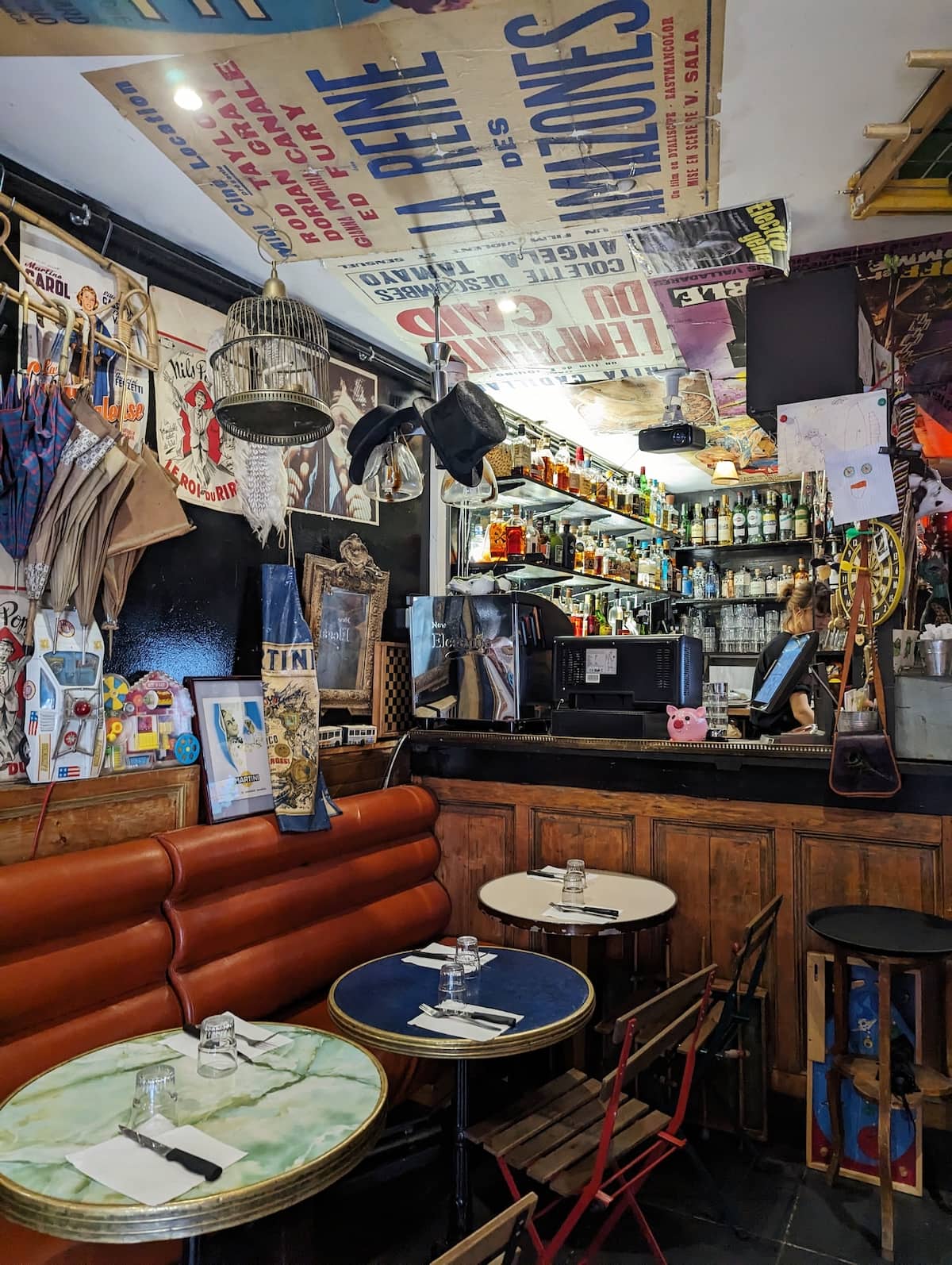 Inside of La Mere Michel, with vintage posters on the walls and ceiling