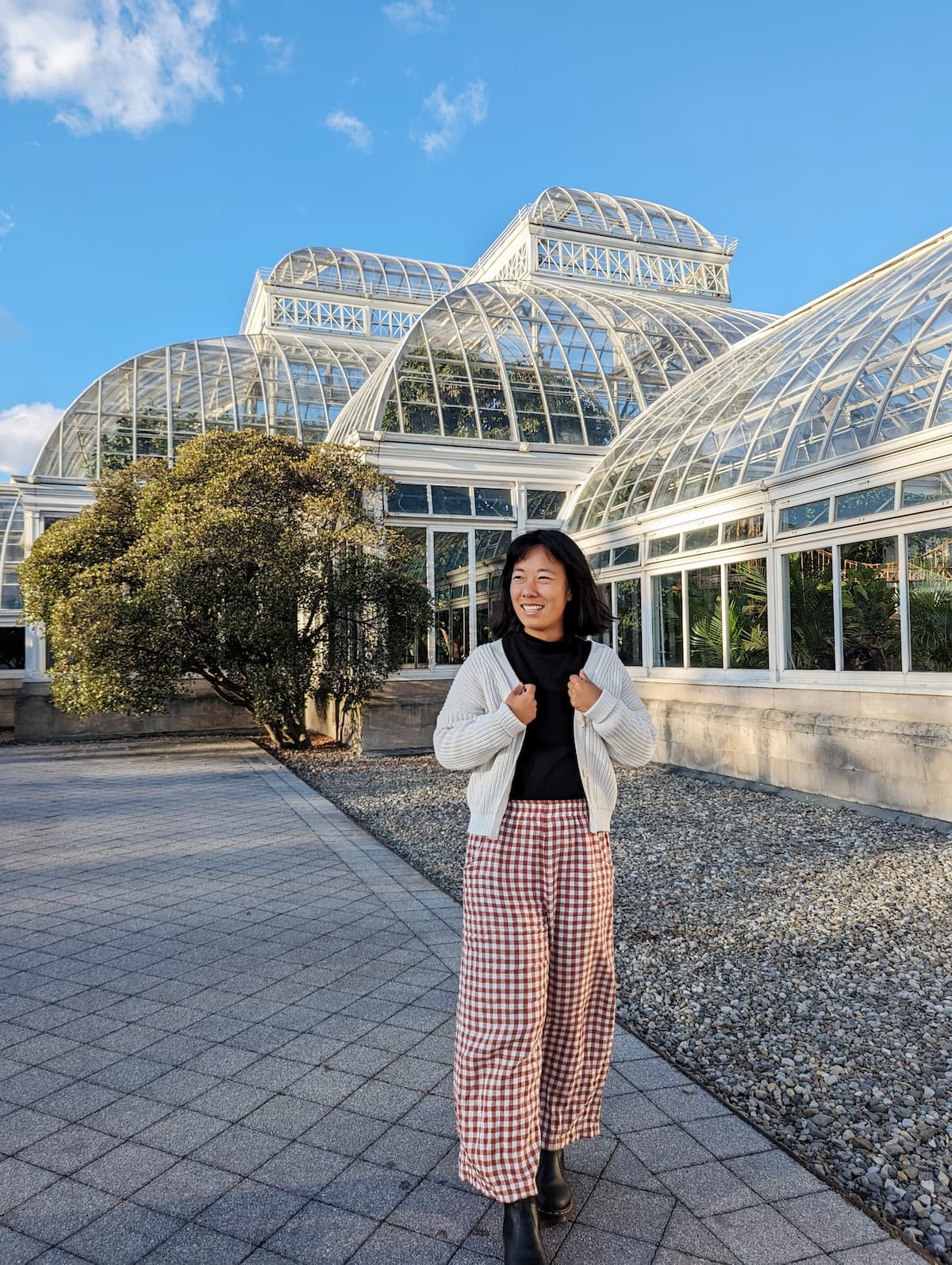 Me wearing the Tradlands Shelter Cardigan in Birch with a black turtleneck, black chelsea boots, and gingham pants
