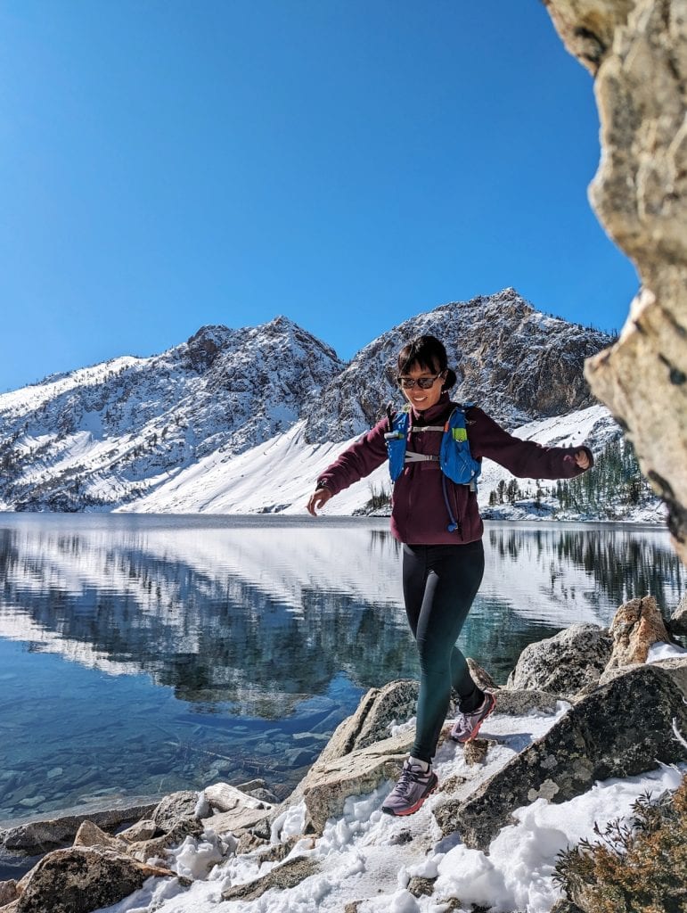 Me trail running along an alpine lake in wintery conditions