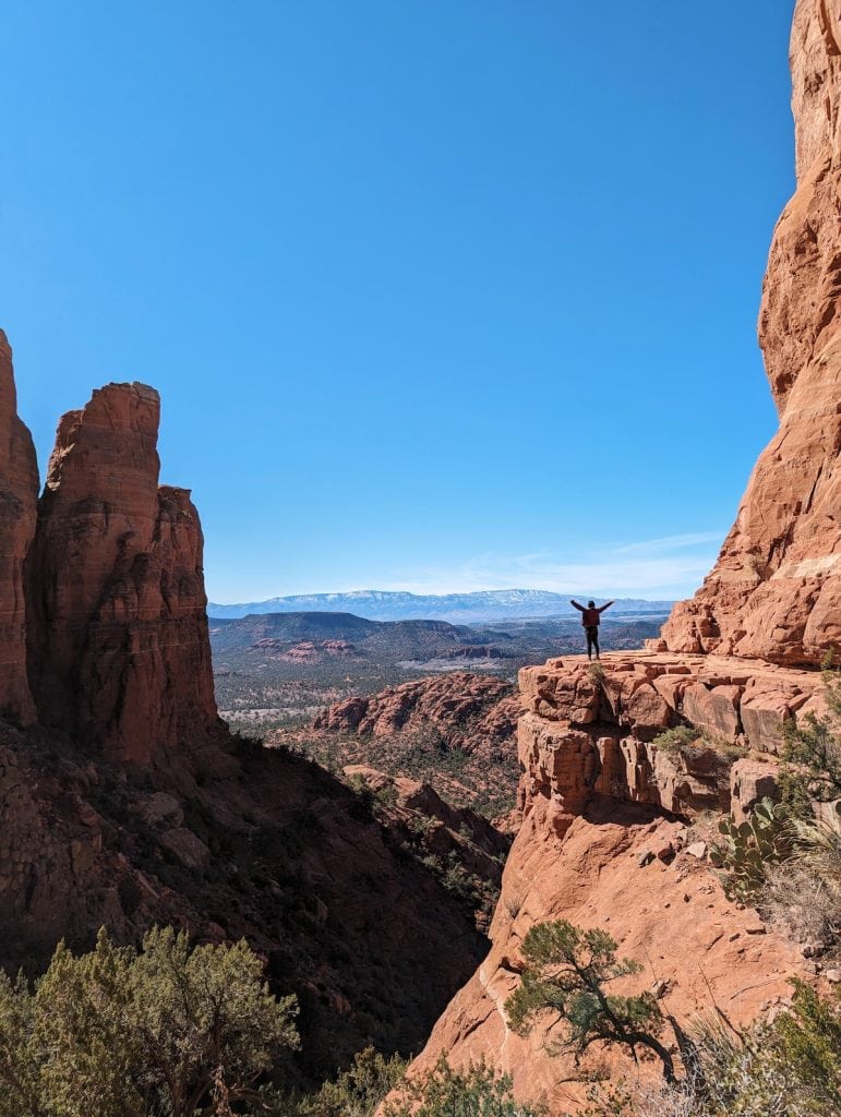 Silhouette of me in the distance holding my hands up on the edge of Cathedral Rock