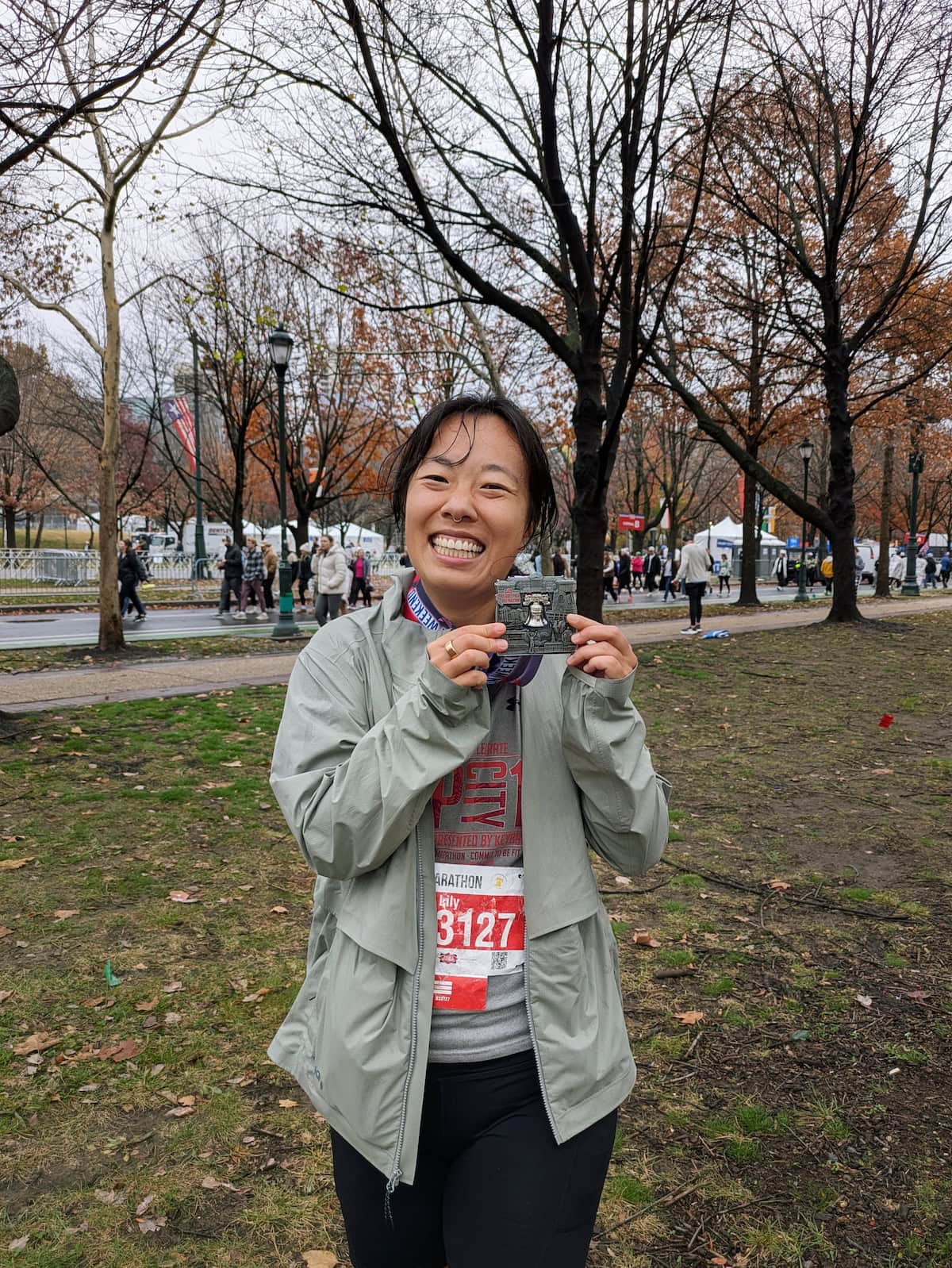 Me wearing the Janji Rainrunner Pack Jacket at the end of the Philly Half Marathon