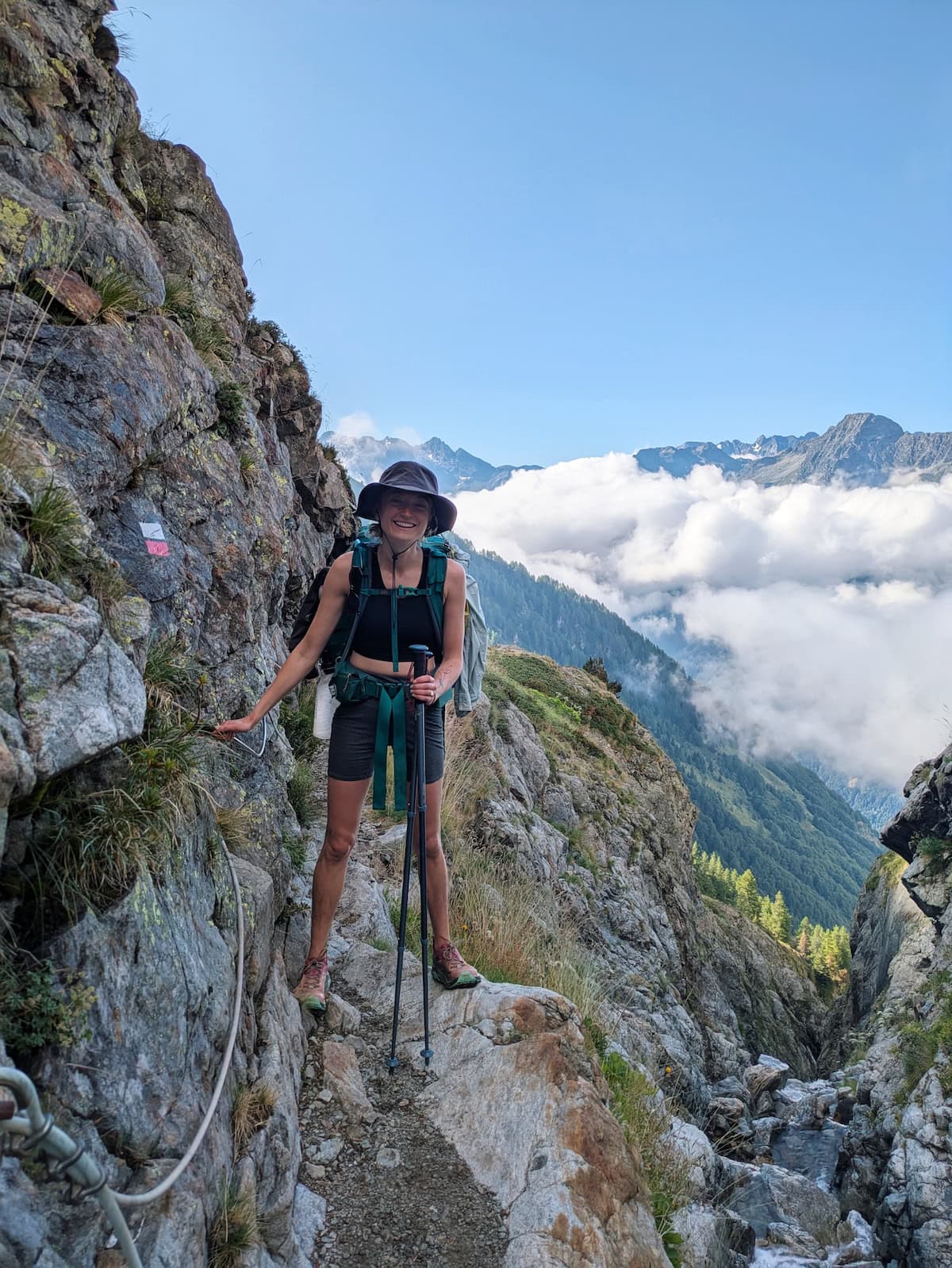 Tessa holding onto some ropes while hiking on the edge of a mountain