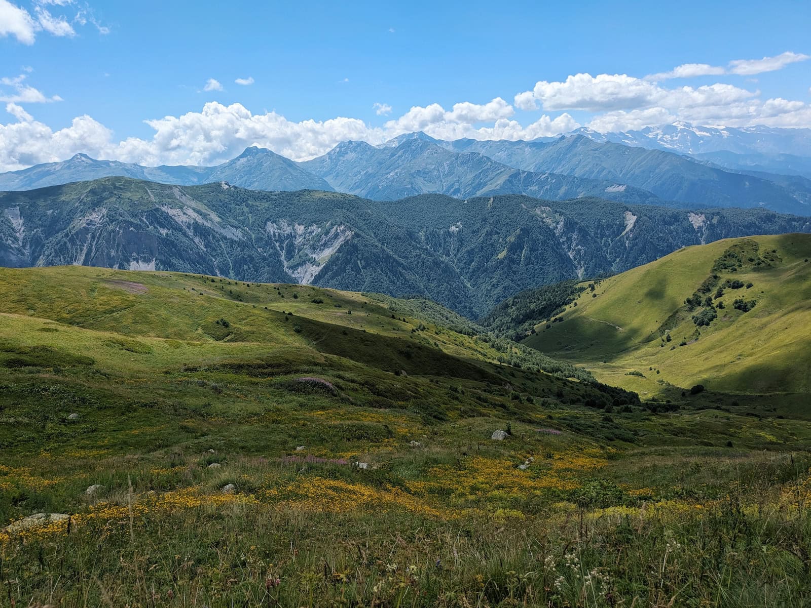 View of the grassy fields and mountains on Day 2 of the Mestia to Ushguli Trek