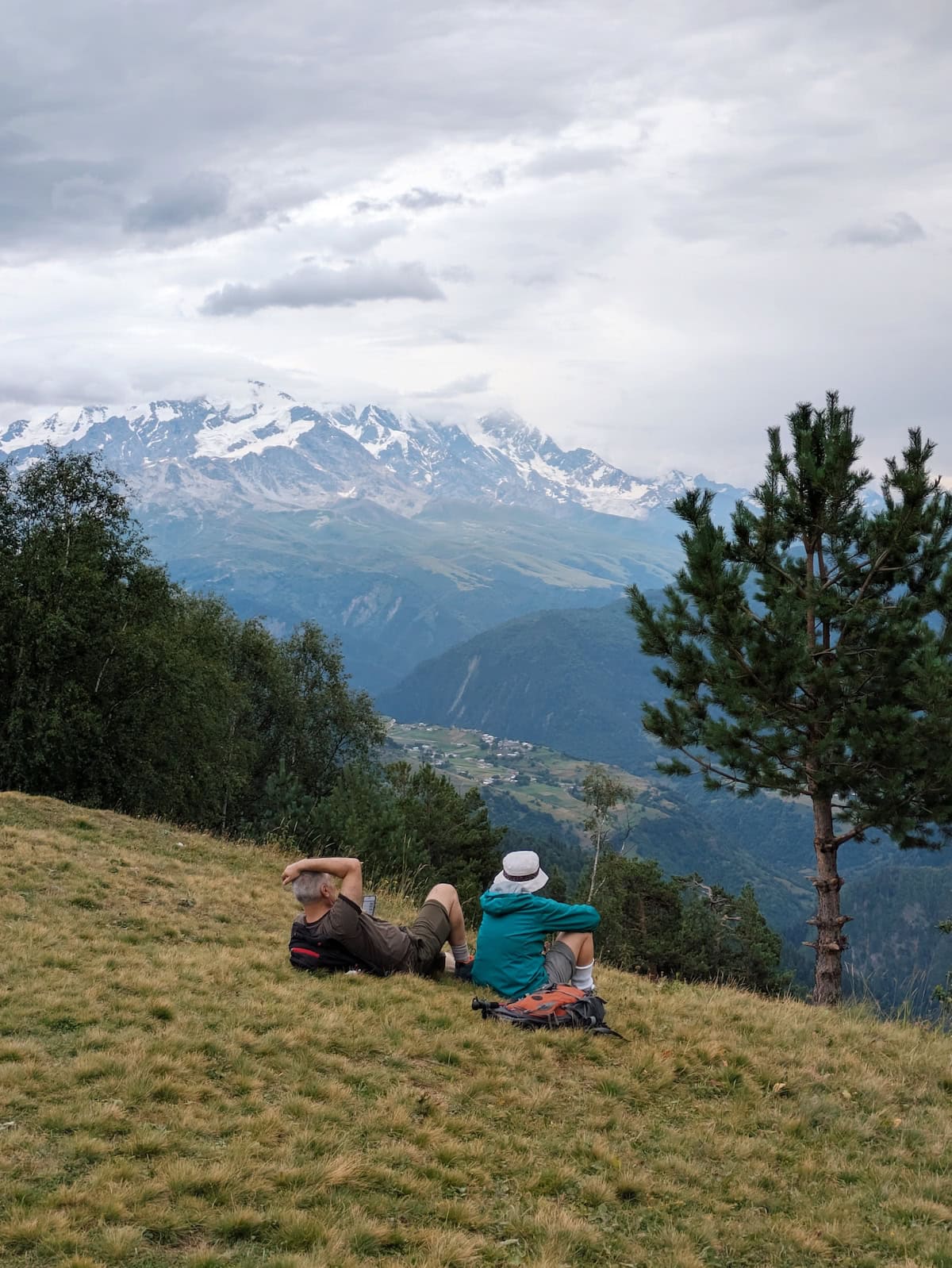 A couple of hikers sitting on the grassy hill at Hatsvali Mountain