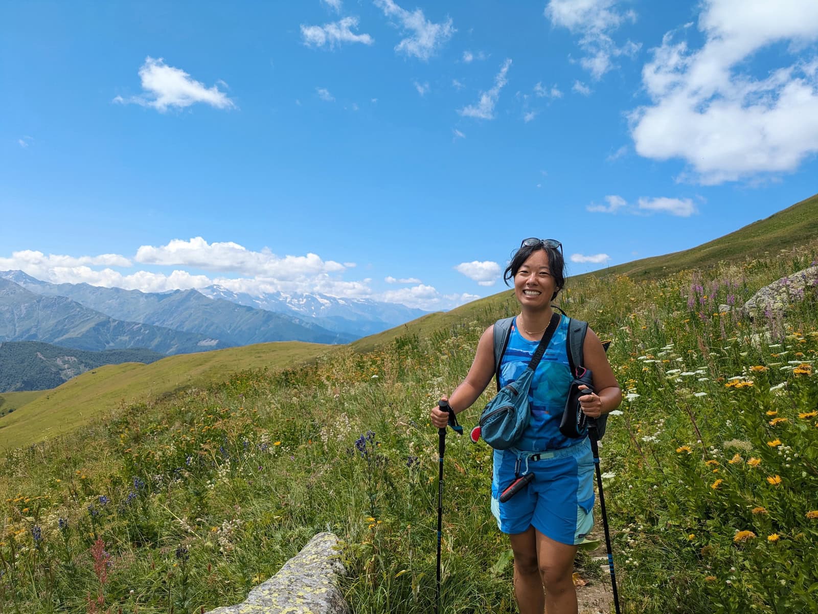 Me in a field of yellow wildflowers at the peak of a mountain